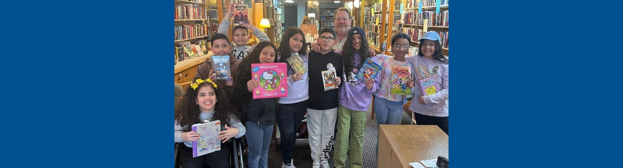 group of kids in bookstore each proudly holding their book choice